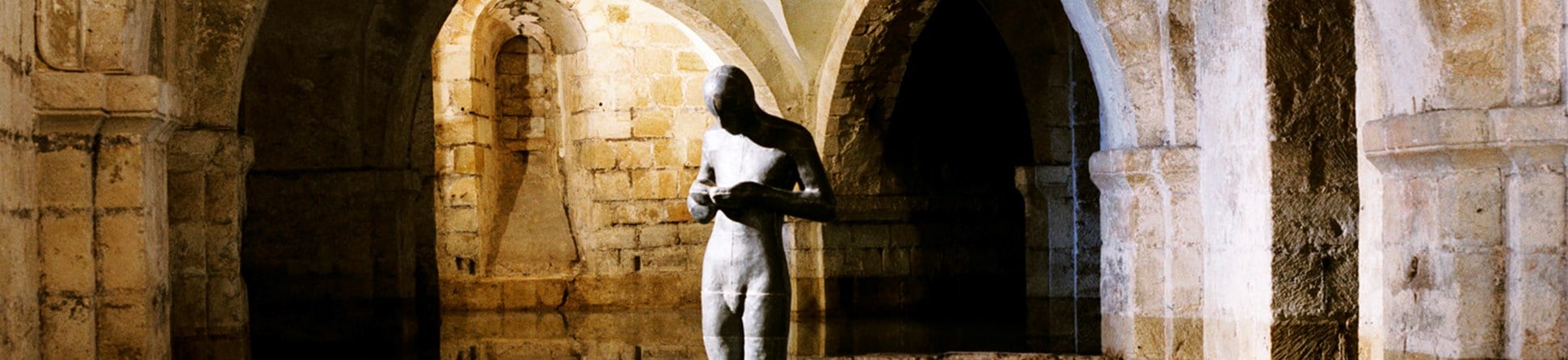 Antony Gormley statue in flooded crypt interior, Winchester Cathedral