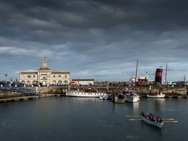 View across Yacht Marina with sea cadets in foreground and the Clock house in the background