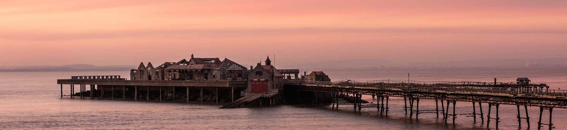 A photograph of a pier at sunset. 