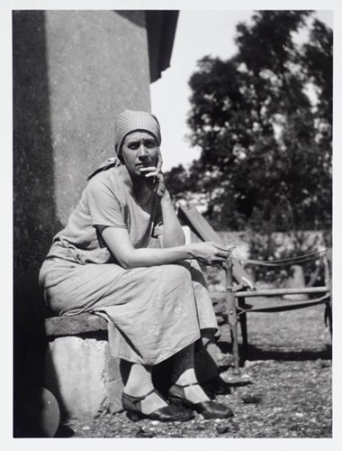 Black and white photo of Vanessa Bell wearing a headscarf at Charleston.