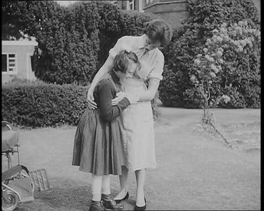 A blind child walking with the assistance of a nurse, A still from the Pathé film No Longer Alone, filmed at an RNIB Sunshine Home. 