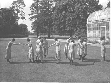Girls dancing on the lawn of the Royal Worcester College for the Blind. 