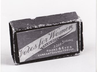 Photograph of a box of ‘Votes for Women’-branded hooks and eyes