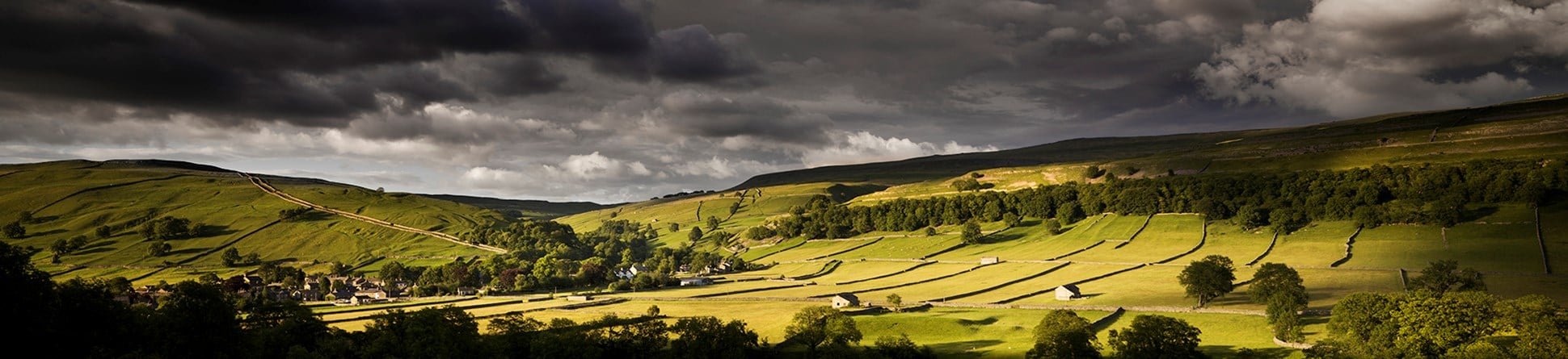 Colour photograph of rural landscape around Kettlewell from the south, showing fields and field barns.