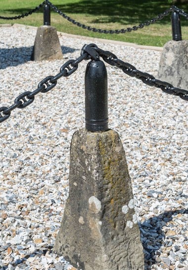 The Leckhampstead obelisk is surrounded by chains, reputed to be from a ship that served at the Battle of Jutland, which hang between 12 shell cases. © Historic England/Jerry Young