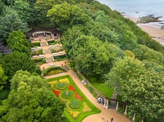 An image of a landscaped garden with the coastline in the background. 