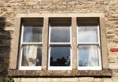 Set of 3 sash windows in a stone building.