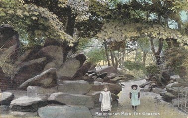 Picture of two children standing next to large rocks in a park.