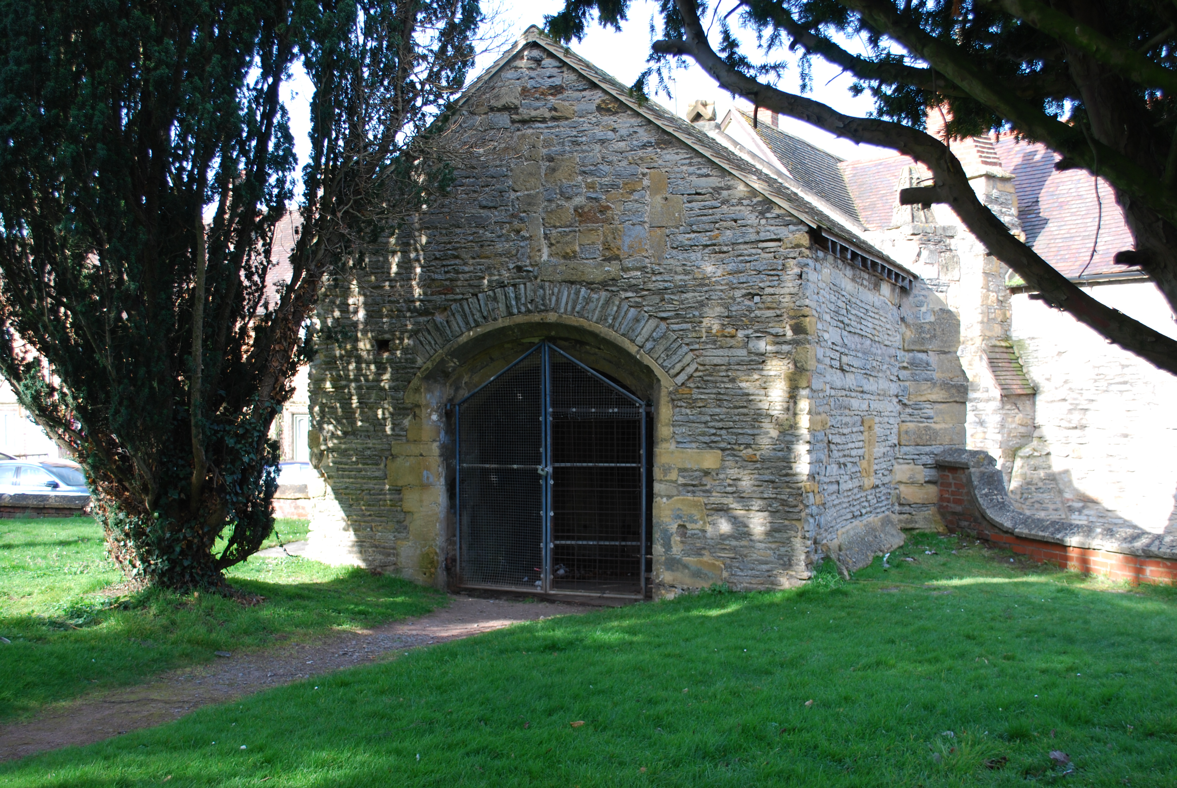 A photograph of the rear of the entrance porch, taken from the grassed area in front of a terrace of houses.