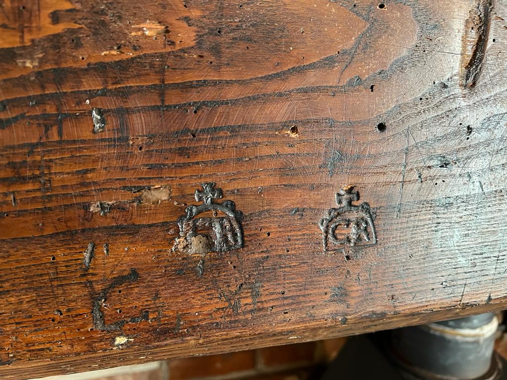 A stirrup shaped design surmounted by a cross and  two rings attached to both sides. Upper case letters inside CA or C