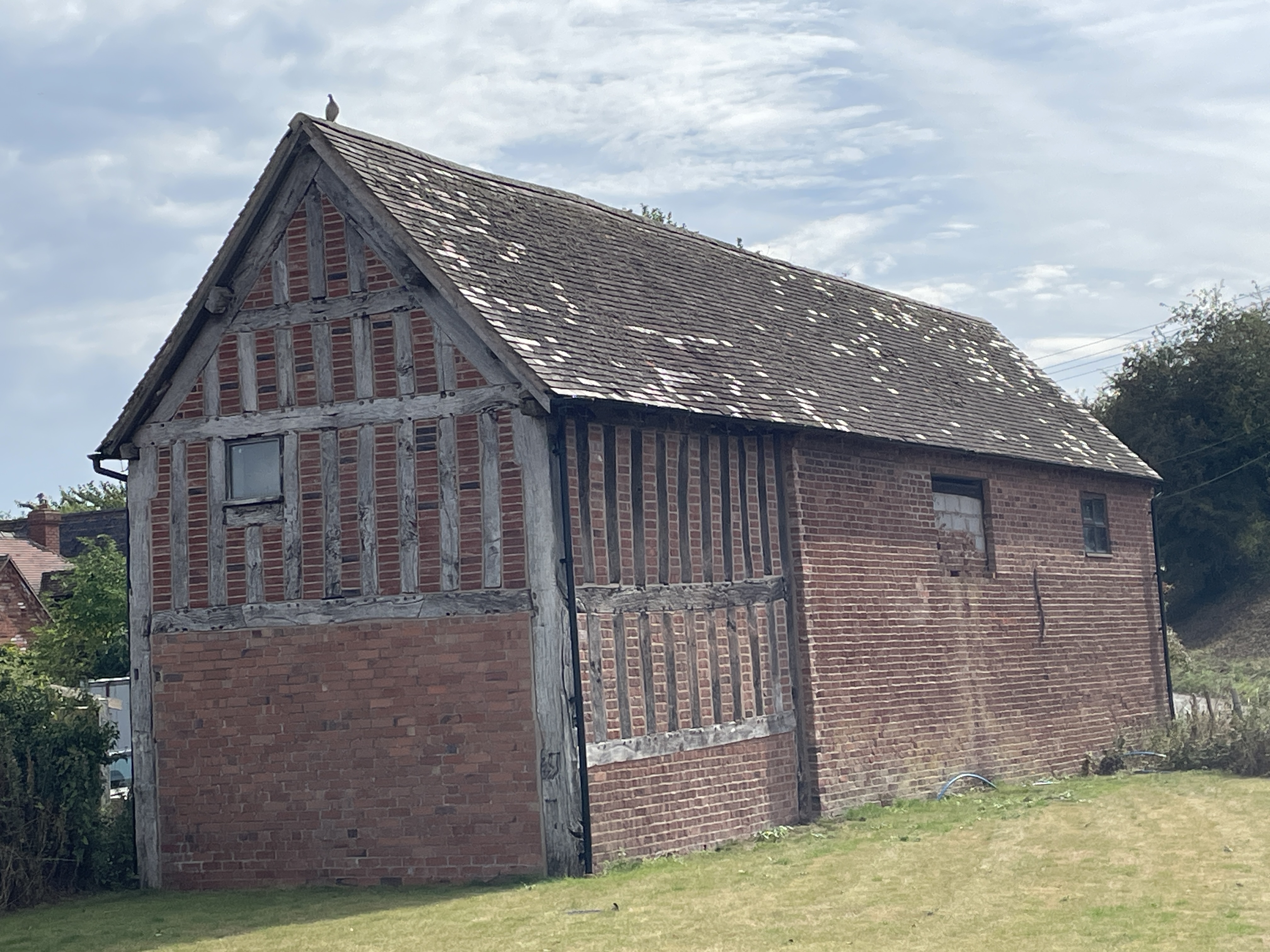 A half-timbered and brick farm building.