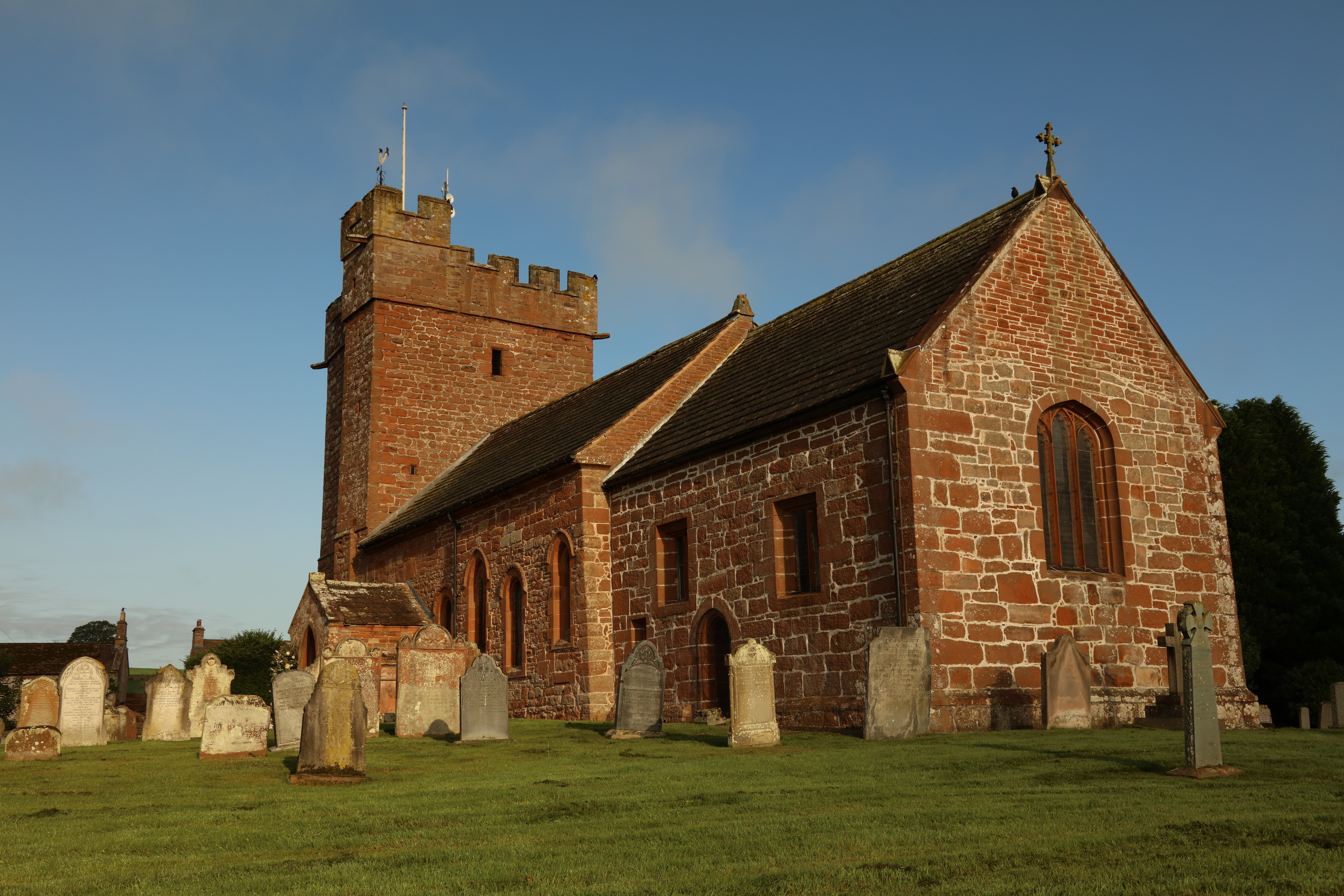 An external view from the rear of St Cuthbert's Church, Great Salkeld. There are some older grave stones by the church
