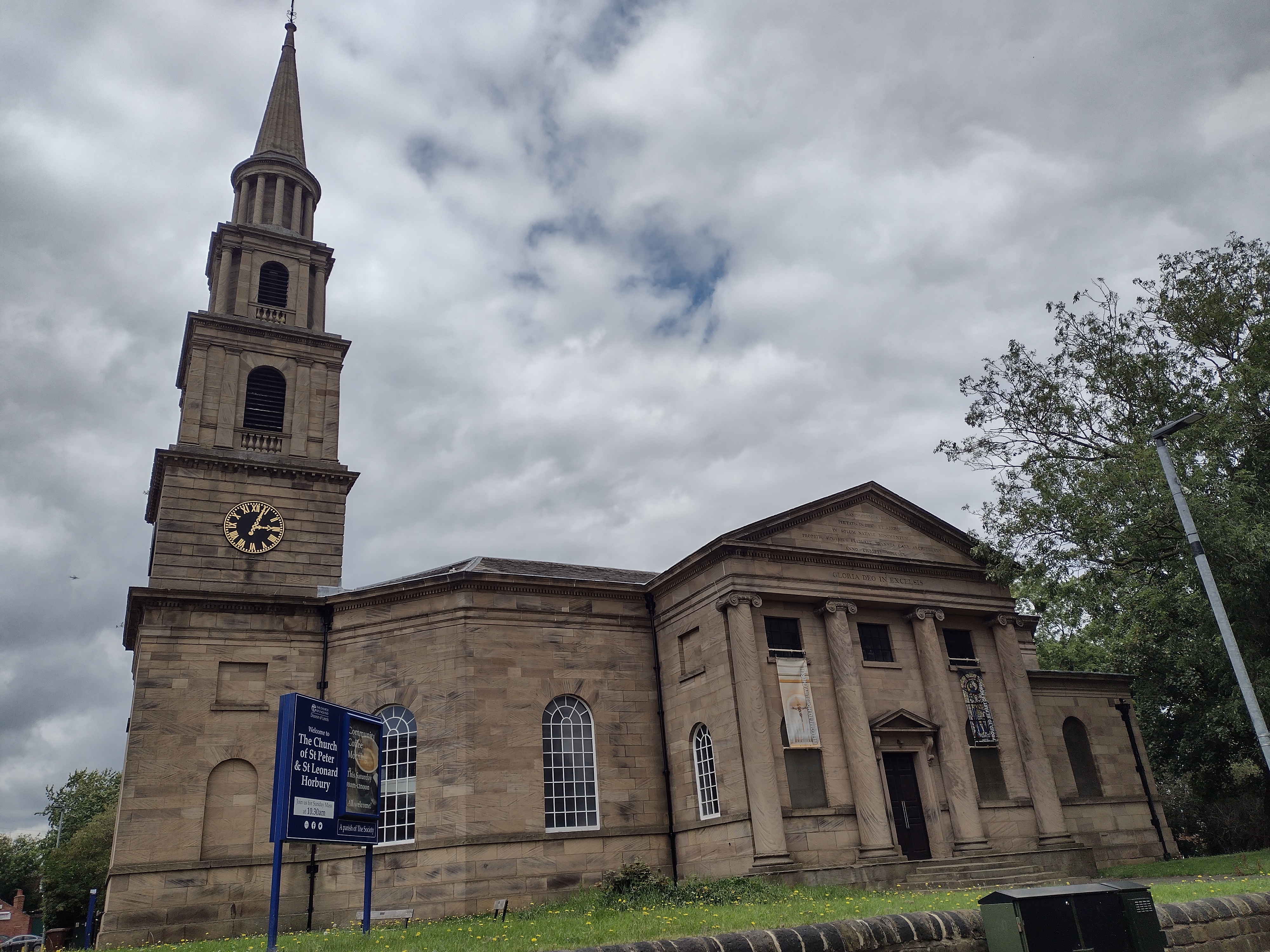 A sandstone church in the classical style. It has an ornate square bell tower, octagonal nave and large portico entrance