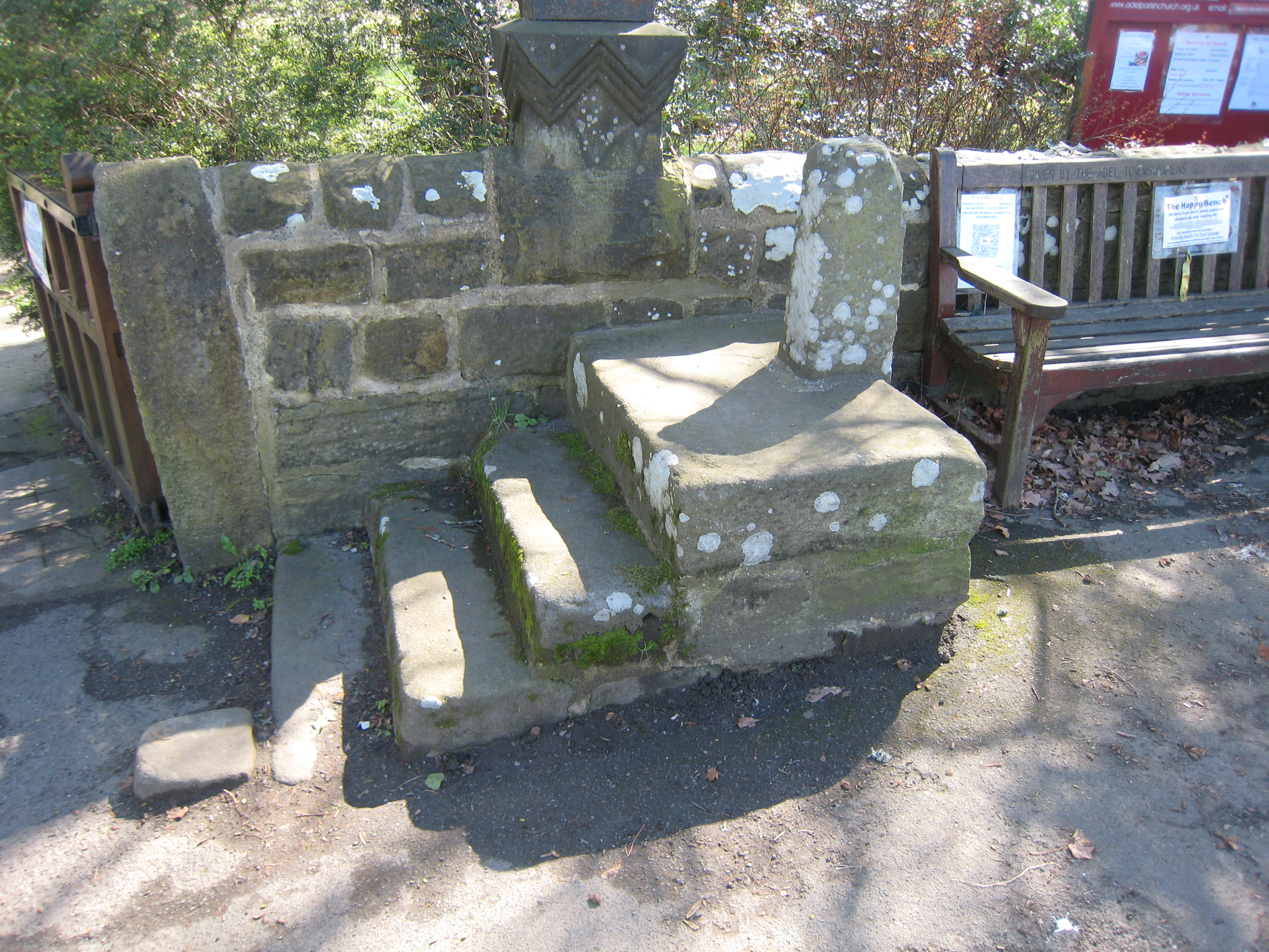 Steps and post in front of a wall.  Bench to right.