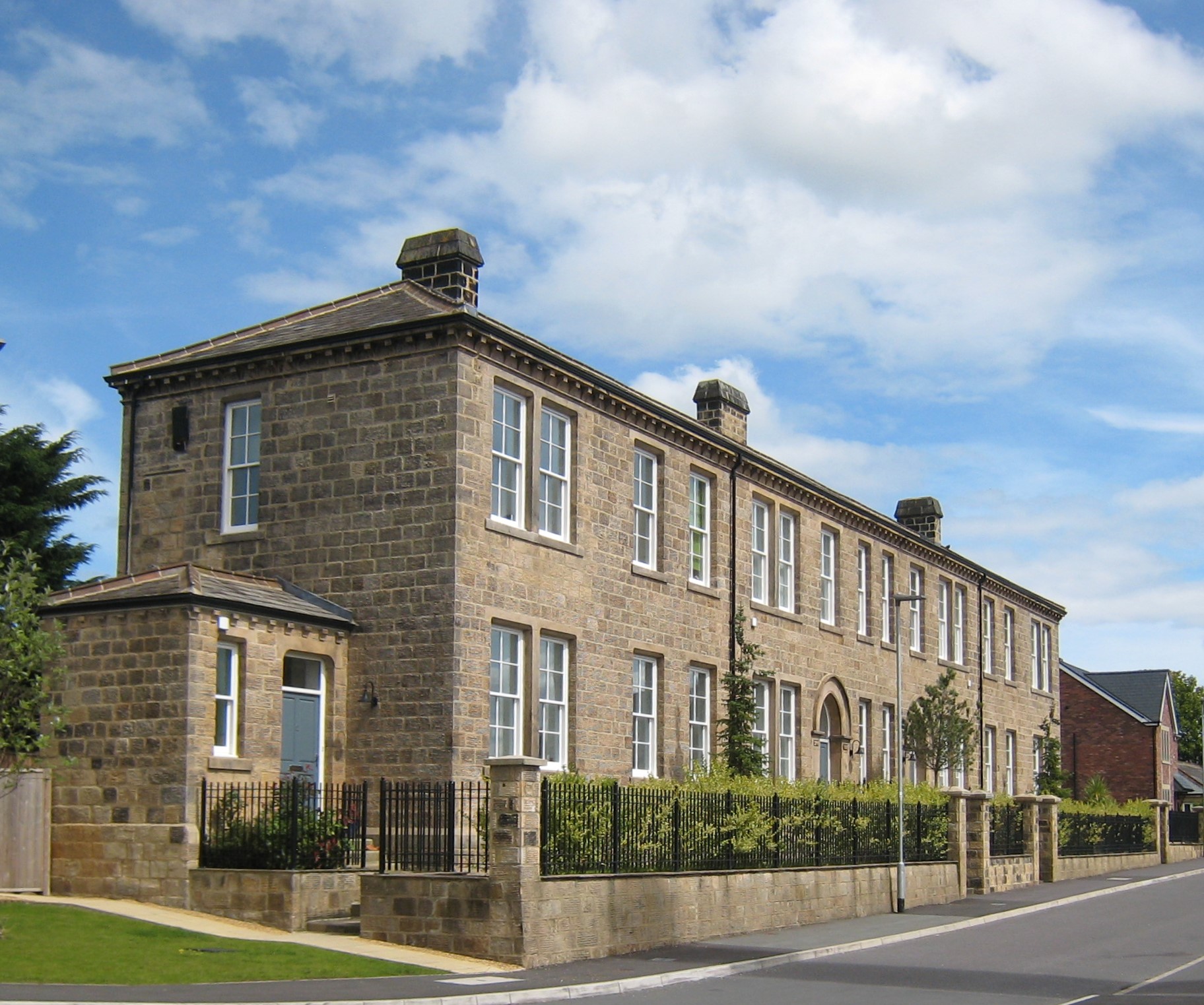 2 storey building in yellow sandstone, end and long view
