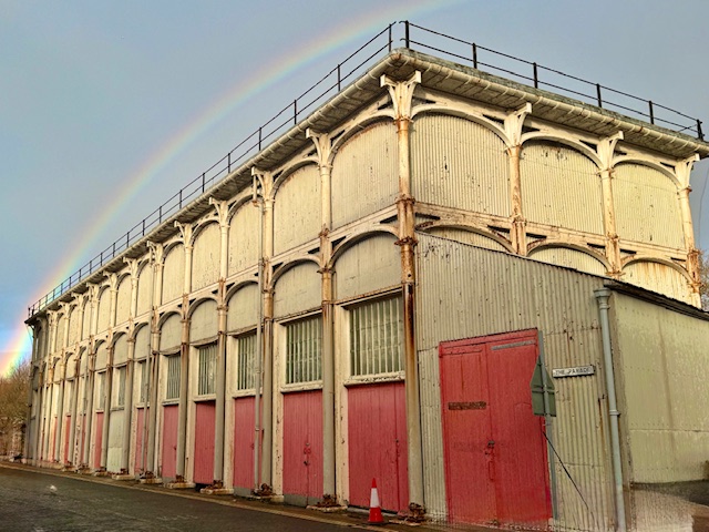 This structure has the cast iron structure visible and large wooden doors painted bright red, clad grey corrugated tin.