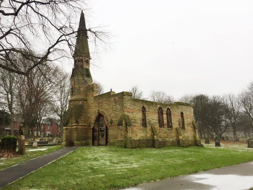 South chapel exterior showing intact tower and chapel walls but no roof. A gate and window grills have now been added. 