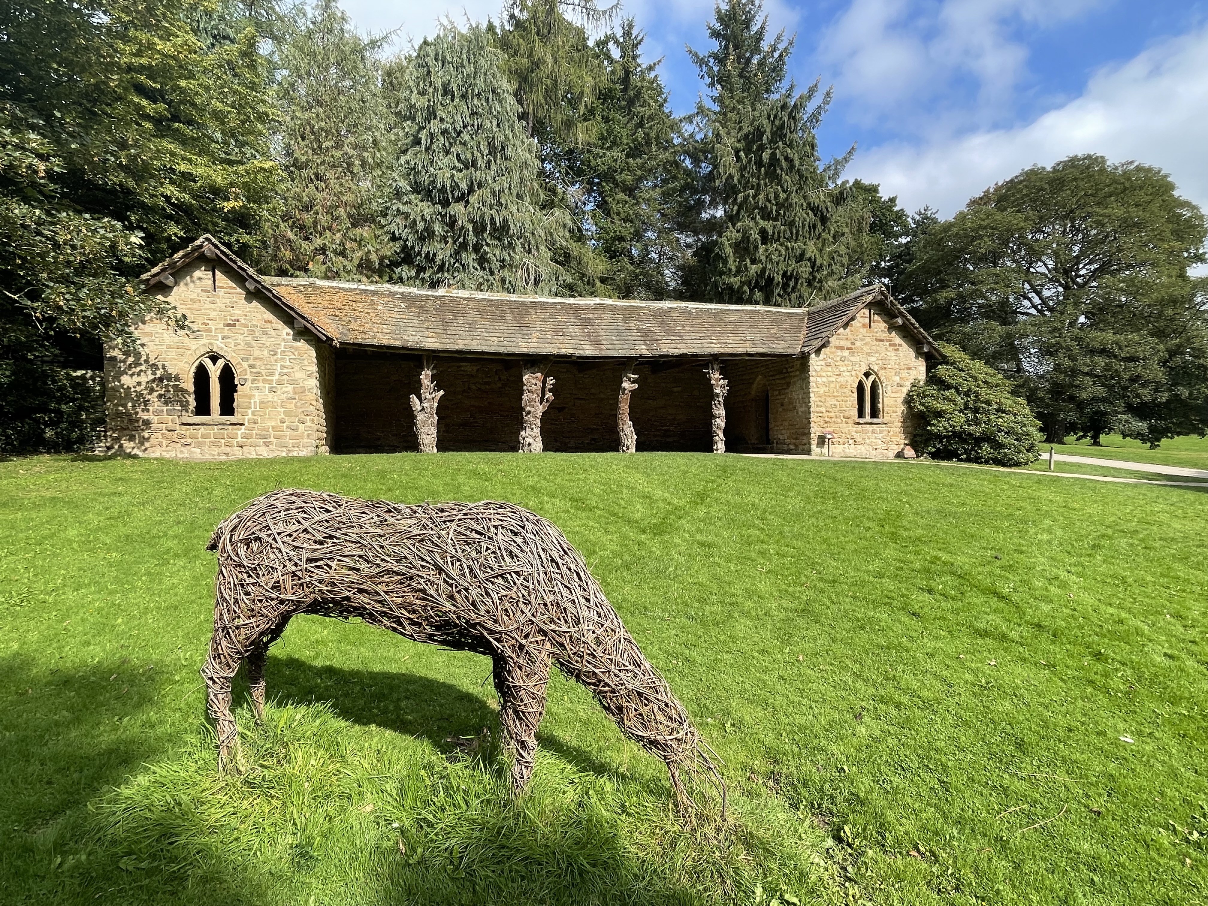 General view from south, with headless deer willow sculpture.