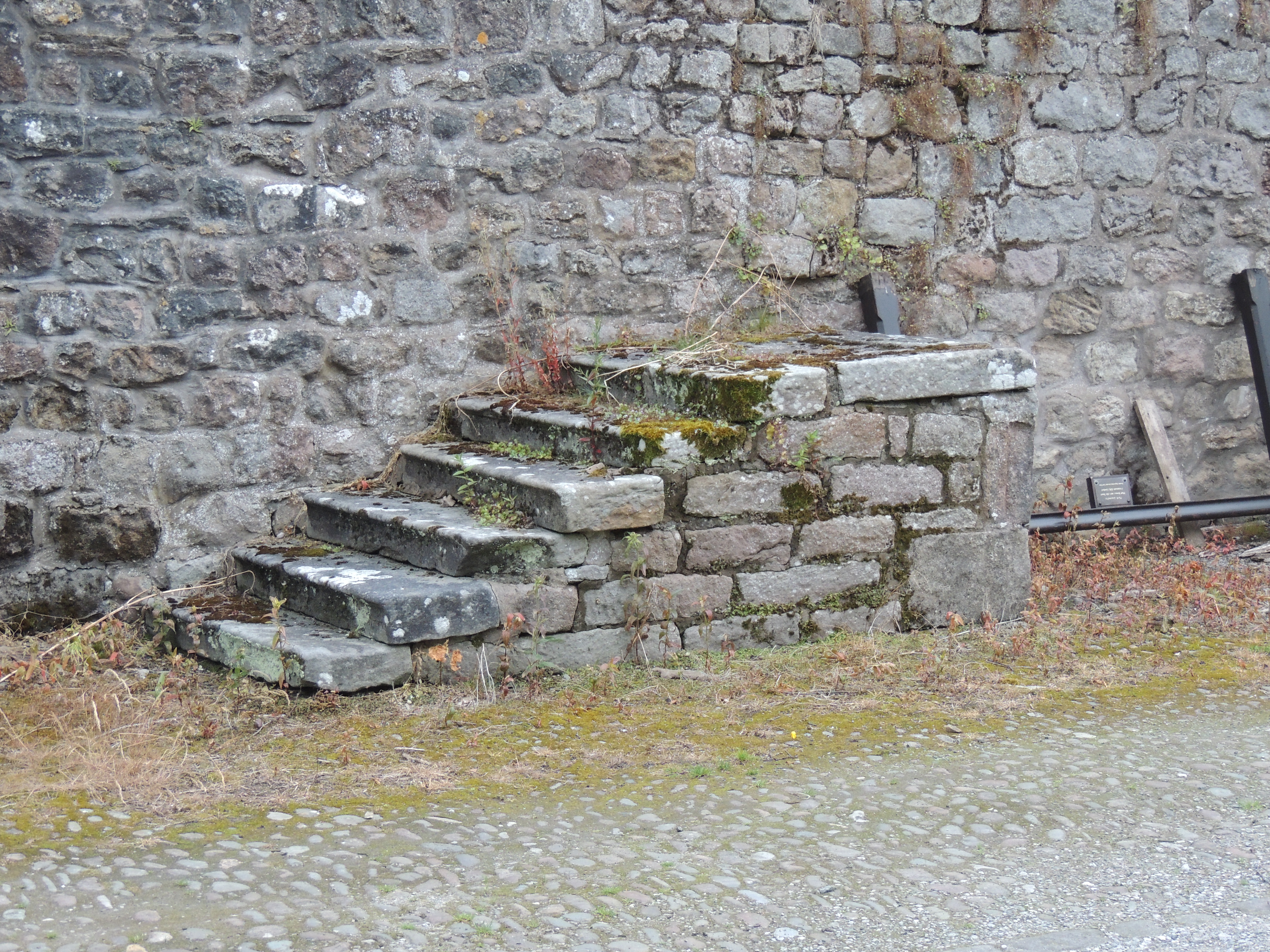 Mounting block, probably 18th century, south of the gatehouse at Ashton Hall. Dressed sandstone on rubble base. 