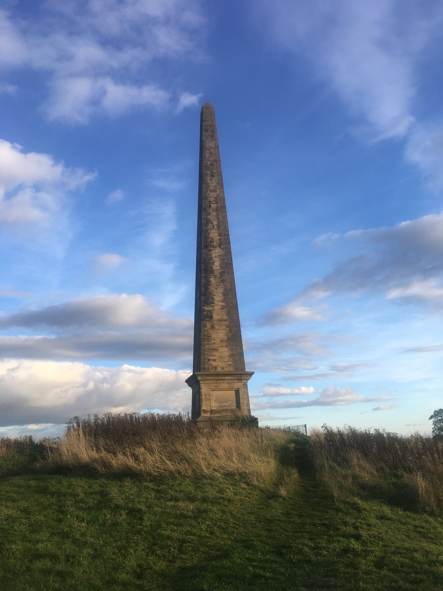 Welcombe Obelisk - hilltop silhouette against blue sky and clouds  