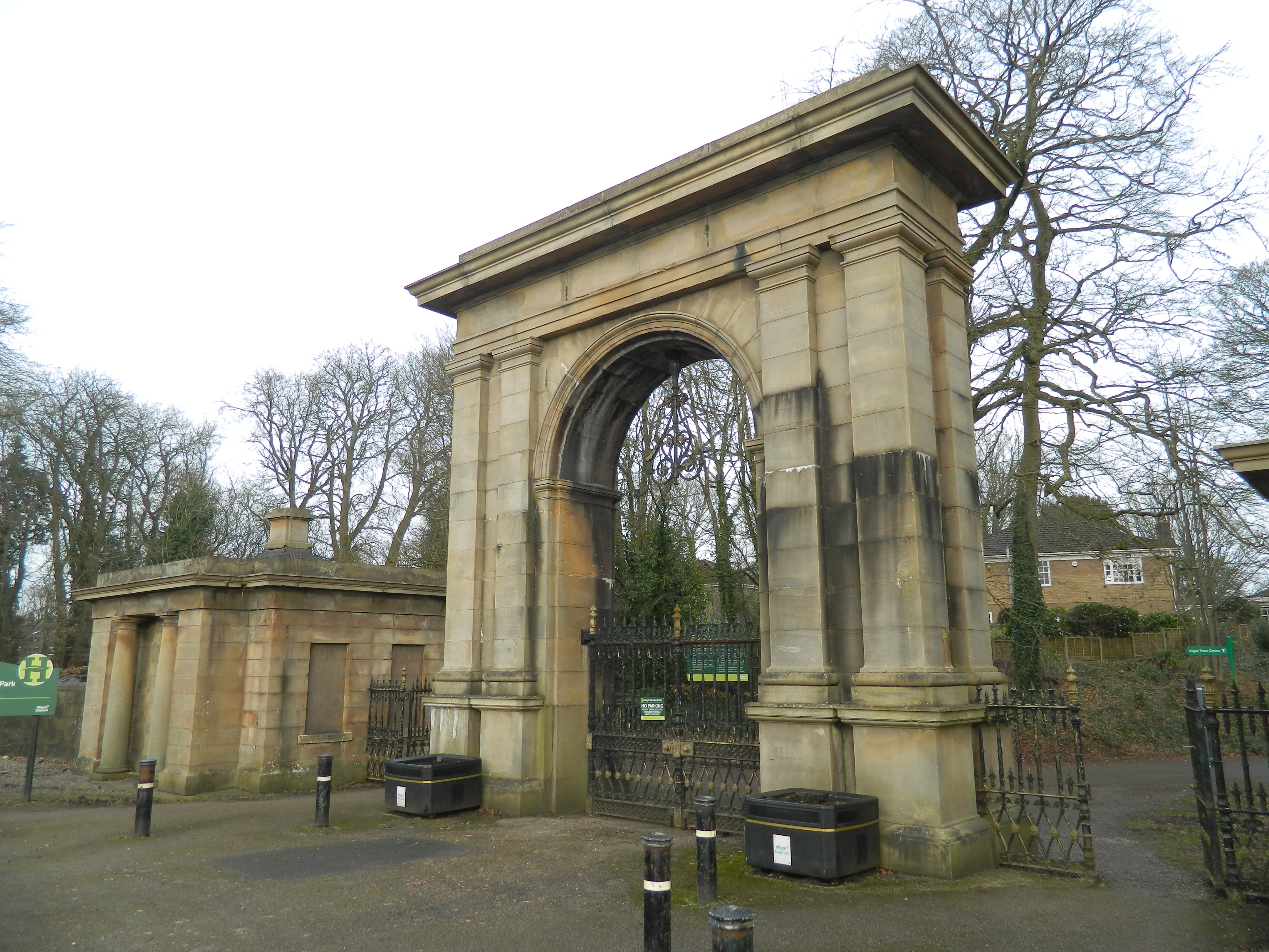 Gateway and Lodges to Haigh Hall Park. An entrance archway & lodges with linking railings & gates. Probably circa 1840.