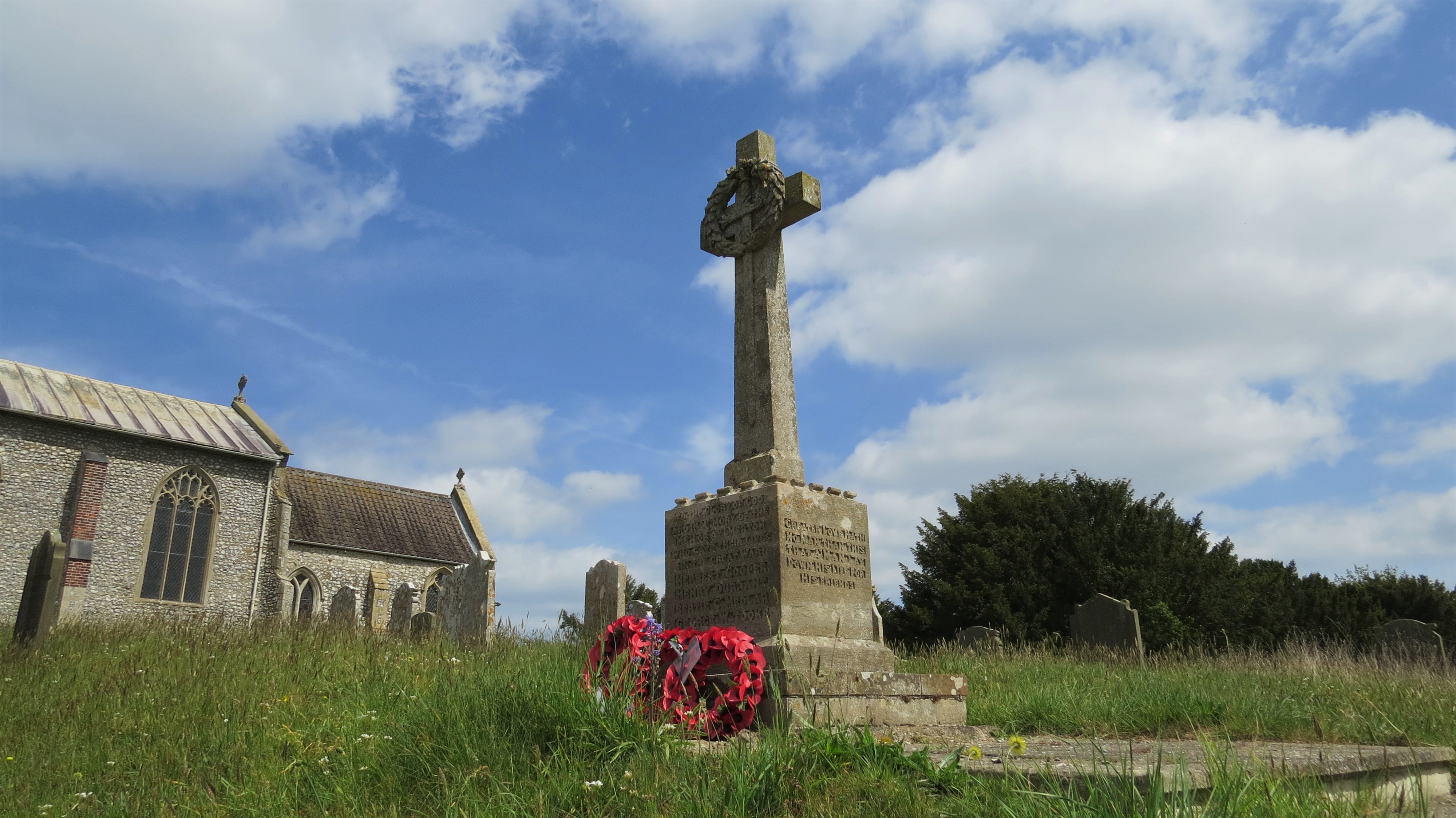 Aylmerton war memorial stands in front of the parish church, St John the Baptist.