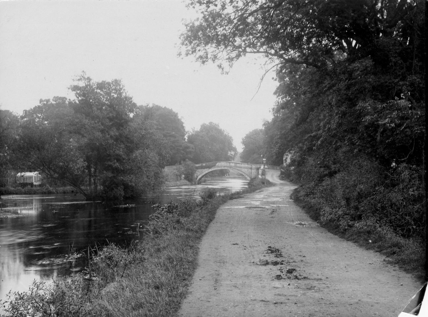 /localA path along a river with a bridge in the background