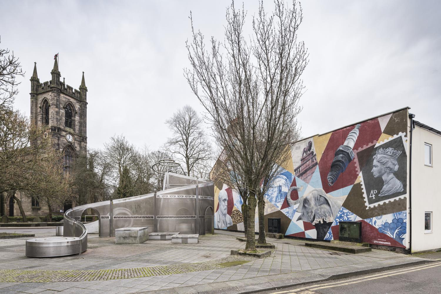 /localA statue and mural in front of a church