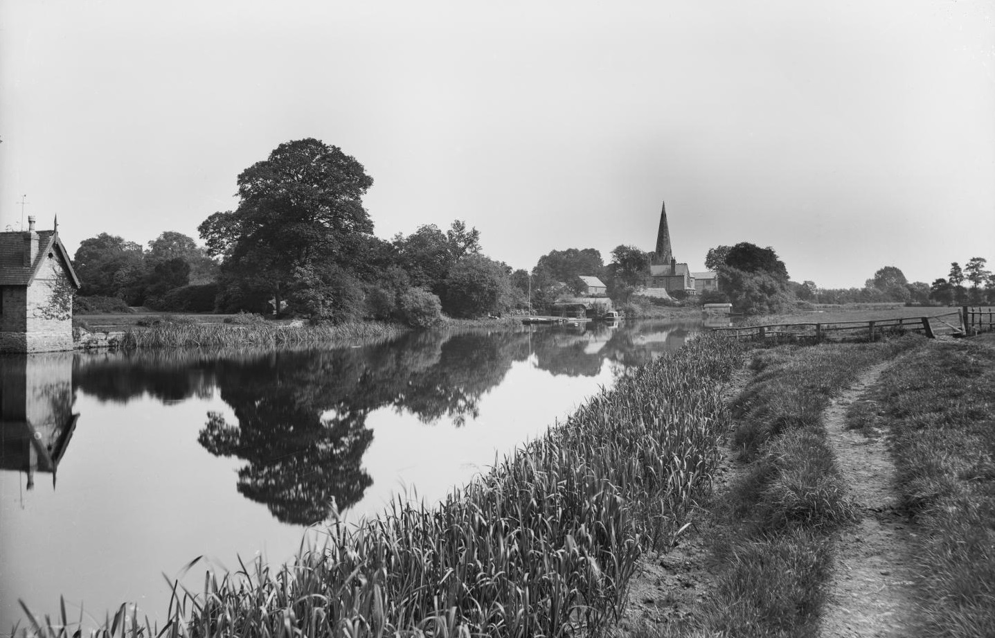 /localA historic photograph with a river in the foreground and trees in the background