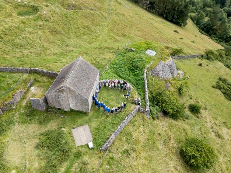 /localPeople in a circle in front of a building ins an aerial view