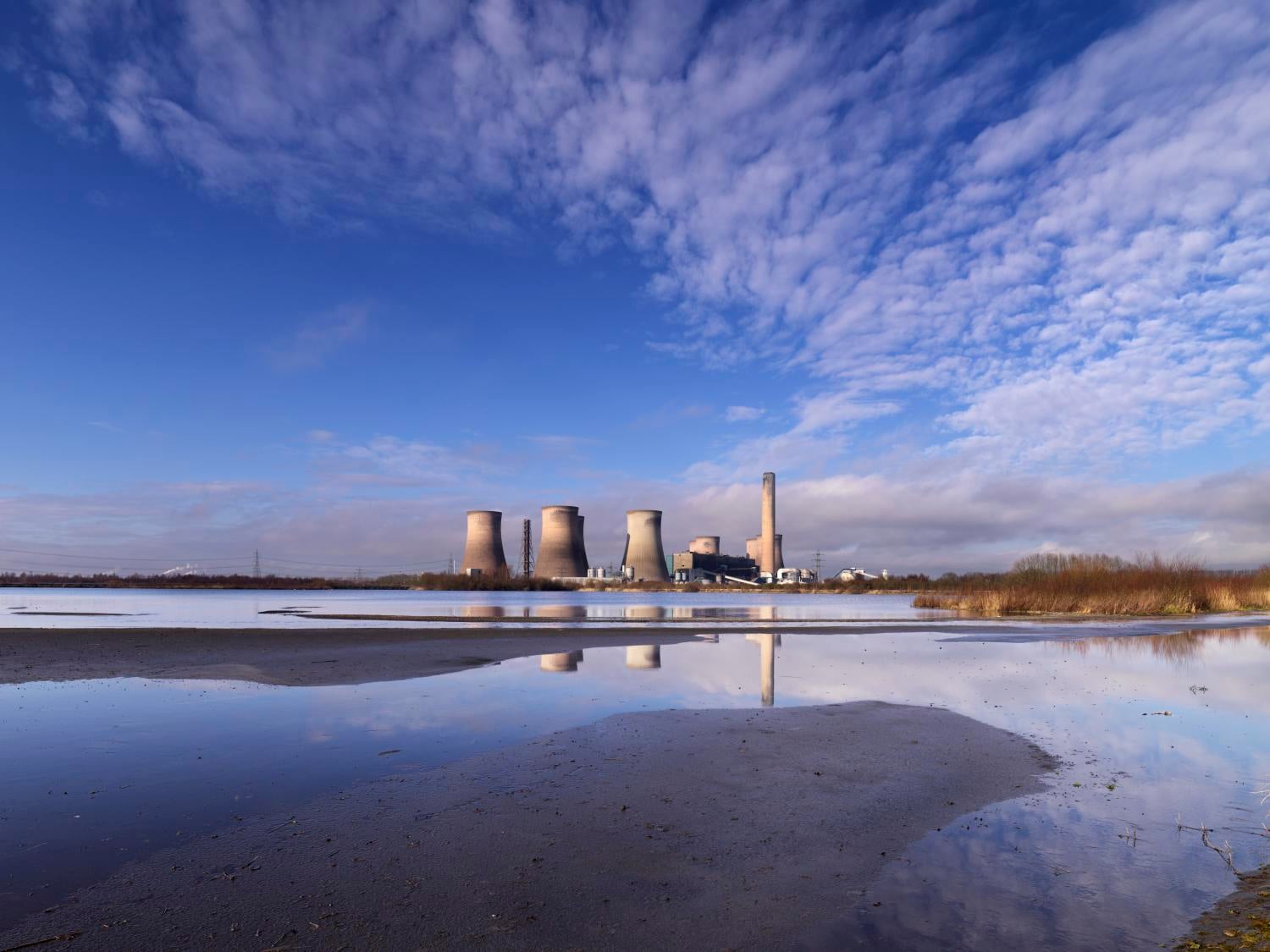 /localA power station in the background of a body of water