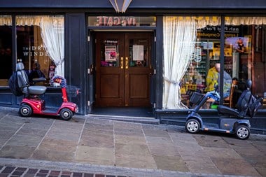 Two mobility scooters parked outside the Drum Winder public house.
