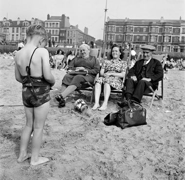 People sitting on the beach in post-war Blackpool