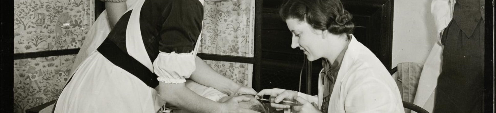 A doctor giving a blood transfusion to a baby by a scalp vein