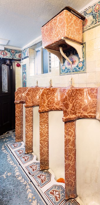 An elaborately decorated urinal within a Victorian pub.