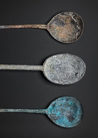 A selection of spoons. Top: copper alloy spoon with round maker’s mark at the base. Centre: pewter spoon. Bottom: copper alloy spoon with round maker’s mark at the base.