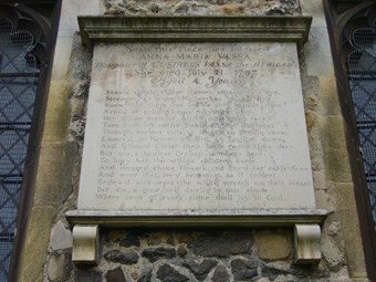 Substantial stone plaque set between windows. The text reads, "Near this place lies interred Anna Maria Vassa daughter of Gustavus Vassa the African. She died July 21 1797 aged 4 years." Below, a verse describes her background, and laments her loss.