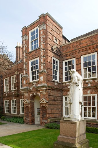 Large 17th-century house in Artisan Mannerist style. Two storeys, with a three-storey tower porch. Red brick with stone dressings. To right, a stone statue of William Wilberforce, seen from the side, standing and leaning on a column.