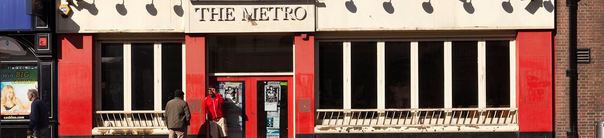 The Metro building and two pedestrians standing outside.