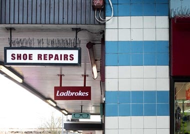 Shops signs for shoe repairs, Ladbrokes and an optician