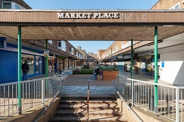 Cross canopy with the words 'Market Place' on the side over stairs leading up to shops