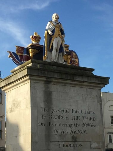 Statue of King George III on a plinth which has the words 'The grateful inhabitants to George the Third on his entering the 50th year of his reign. J Hamilton.' inscribed on it.