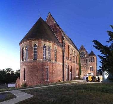 General view of the former pumping station, illuminated at dusk