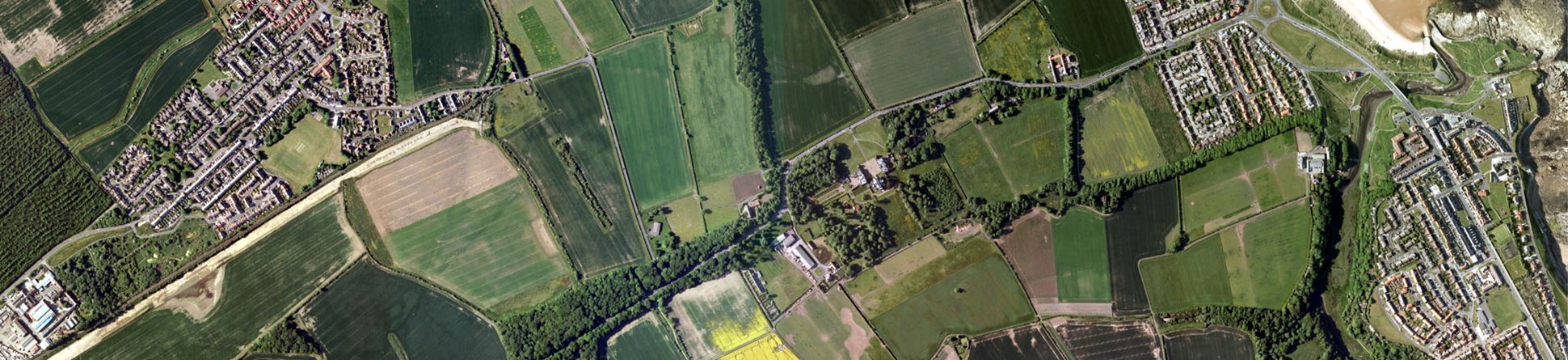 Colour aerial photo of a transect through a landscape with modern housing developments bordering arable fields with some trees