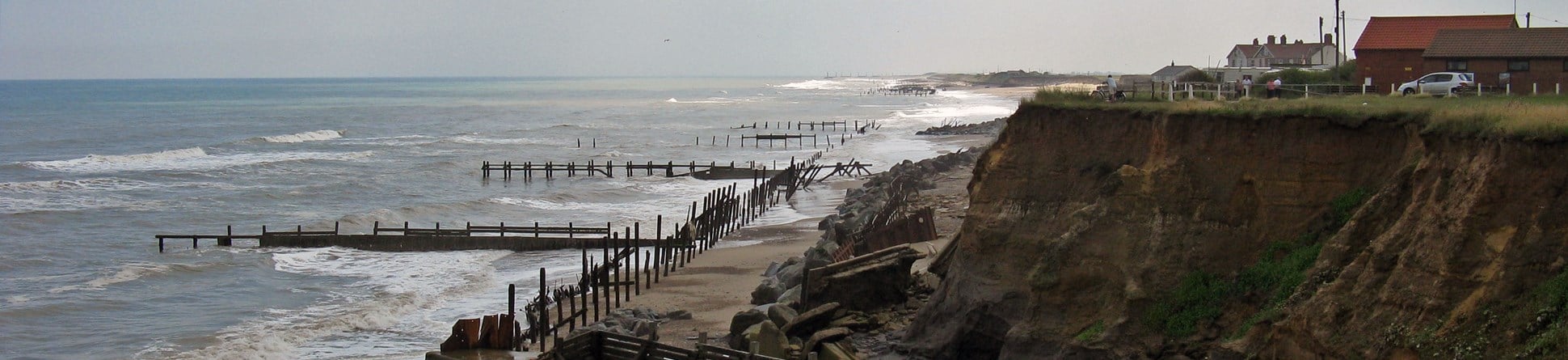 Colour photograph of defunct sea defences and eroding till cliffs at Happisburgh, Norfolk