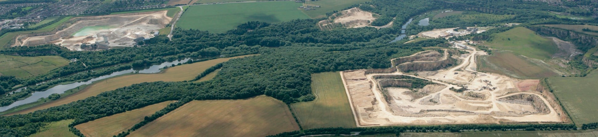 Colour aerial photograph showing a couple of large quarries with a tree lined river running between them