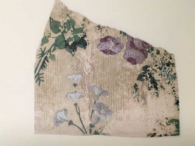 A detail of a historical wallpaper with a floral pattern of white and mauve flowers. The green pigment contains arsenic.