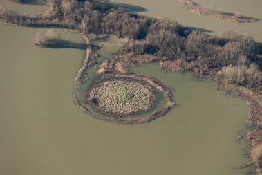 Aerial view of mound surrounded by floodwater