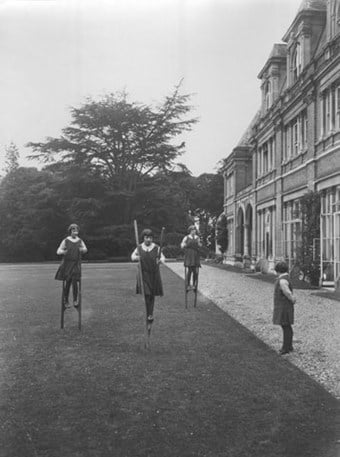 Girls walking on stilts at the Royal Worcester College for the Blind.