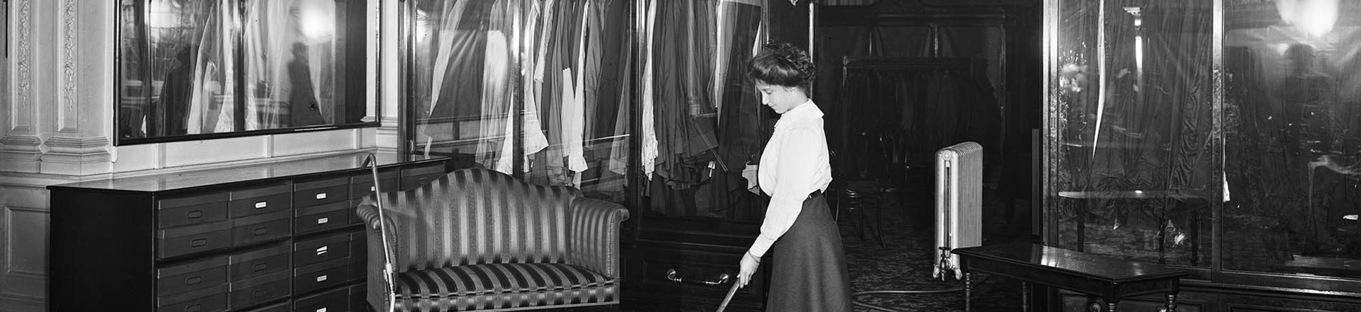 A female shop worker operating a vacuum cleaner